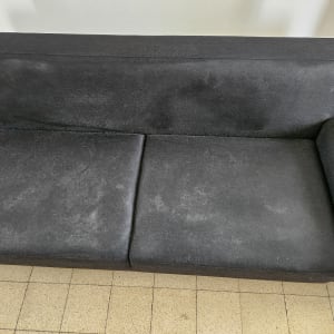 ספה כהה עם כתמים על המושב והמשענת