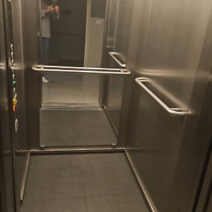 מראה גדולה בתוך מעלית עם השתקפות אדם