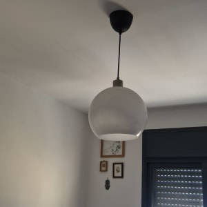 מנורה תלויה מהתקרה בחדר עם חלון