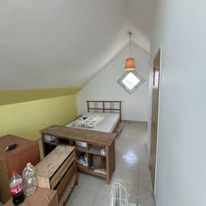 חדר עם קירות צבועים בלבן וצהוב, מיטה ורהיטים