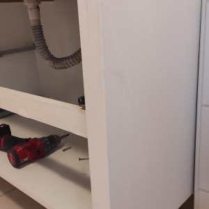 ארון עץ עם נזק, מקדחה וברגים על הרצפה