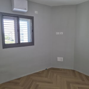 חדר ריק עם קירות צבועים ורצפת פרקט