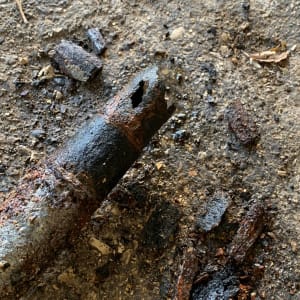 צינור חלוד עם חור על הקרקע