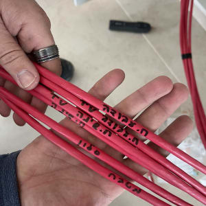 טכנאי מחזיק כבלים אדומים עם כיתוב בעברית