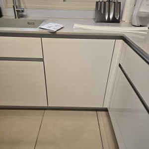 מטבח עם ארונות לבנים וסכינים על השיש