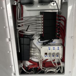 ארון תקשורת עם כבלים ומתגים, מתאים לטכנאי רשתות.