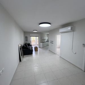 חדר משופץ עם רצפת אריחים, מזגן וספה.