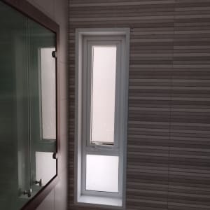 חלון צר עם תריסים סגורים בחדר אמבטיה