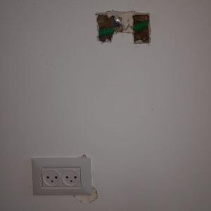 שקע חשמלי בקיר עם חור ותשתית ירוקה