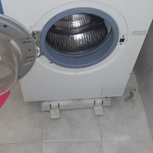 מכונת כביסה עם דלת פתוחה ותוף נירוסטה