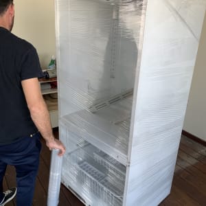 אדם עוטף מקרר בניילון נצמד להעברה