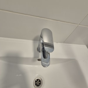 ברז כרום וכיור חרסינה מבריקים ונקיים בחדר רחצה