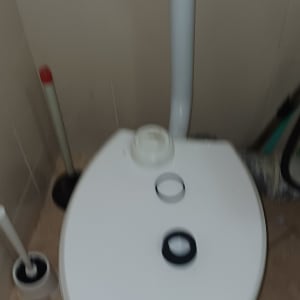 אסלה עם חלקים על המכסה בחדר אמבטיה