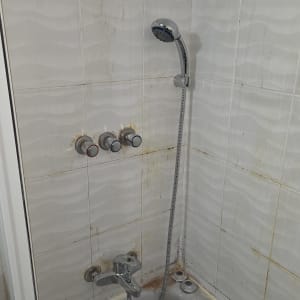 ברזים ומקלחת באמבטיה עם סימני חלודה