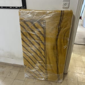 מזרן עטוף בניילון עומד ליד קיר