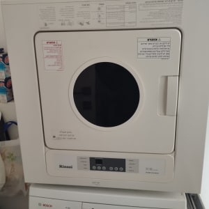 מכונת כביסה ומייבש עם מוצרי ניקוי בצד