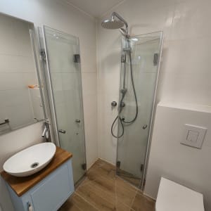 מקלחון זכוכית עם ראש מקלחת מתכתי עגול