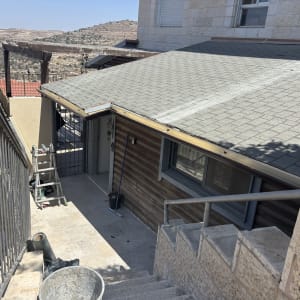 גג רעפים עם סולם וכלי עבודה ליד מדרגות חיצוניות