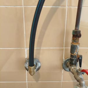 צינור שחור מחובר לקיר עם מחבר מתכת