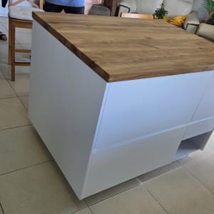 אי מטבח עם משטח עץ וכיסאות מסביב