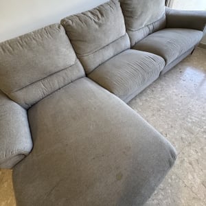 ספה אפורה עם כתמים על הרצפה