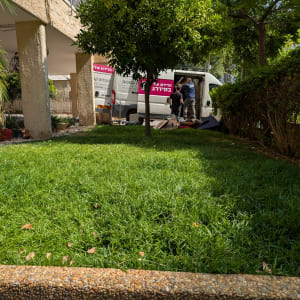 שני אנשים מעמיסים ציוד לרכב מסחרי לבן