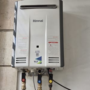 מחמם מים גז מותקן על קיר עם צינורות חיבורים