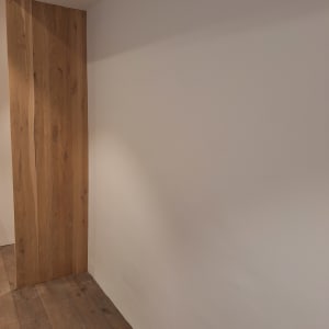 קיר צבוע בלבן עם רצפת עץ