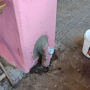 צינור מים מתוקן עם טיח על קיר ורוד