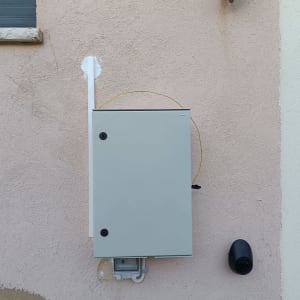 ארון חשמל מותקן על קיר חיצוני עם חוטים מחוברים