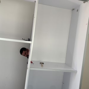 אדם מרכיב ארון עם מברג ופטיש