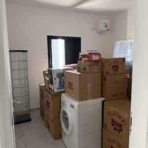 חדר מלא בארגזים ומכונת כביסה, מוכן להובלה