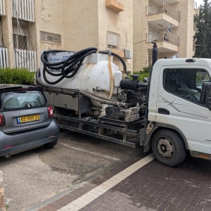 משאית שאיבה עם מיכל גדול וצינורות שחורים