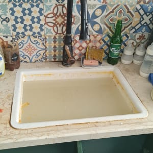 כיור מטבח עם מים עומדים וברז שחור