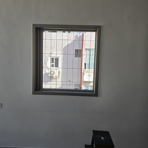 חלון עם סורג, מקדחה ושרפרף בחדר ריק