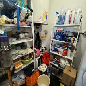 מדפים עם חומרי ניקוי, מגבות, קופסאות פלסטיק ודלי