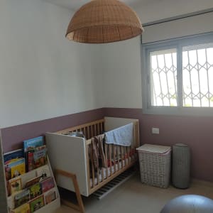 חדר ילדים עם קיר צבוע בשני צבעים