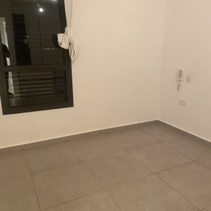 חדר ריק עם רצפת אריחים וחלון