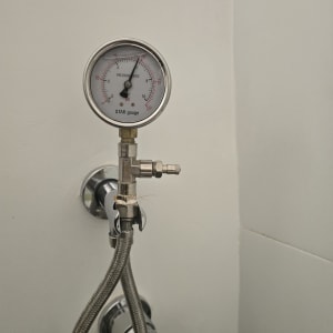 מד לחץ מים מחובר לצינור, חלק מעבודת איתור נזילות