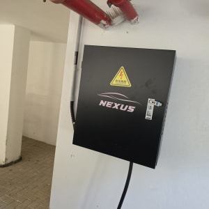 ארון חשמל עם שלט אזהרה וצינורות אדומים