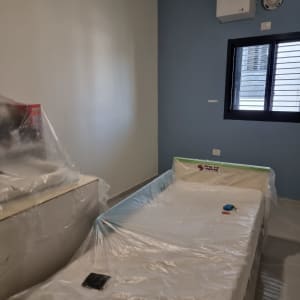 חדר צבוע עם רהיטים מכוסים בניילון