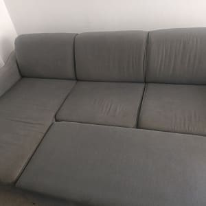 ספה אפורה בחדר עם קיר לבן