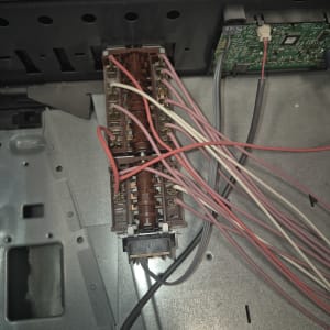 חוטים צבעוניים מחוברים ללוח חשמלי בתוך מכשיר