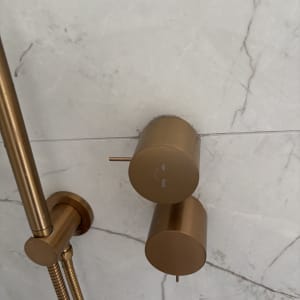 ברזים מוזהבים על קיר שיש