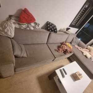 ספה אפורה עם כריות ושמיכות