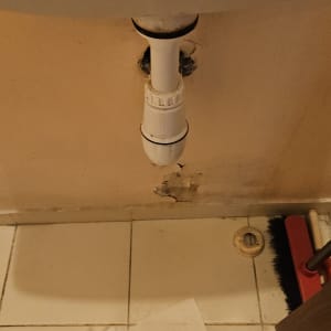 כיור עם צינור ניקוז וקיר פגום