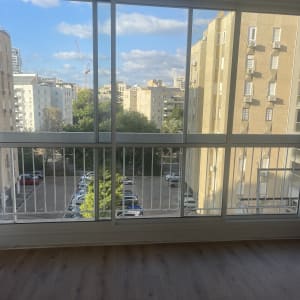 חלונות ויטרינה גדולים ונקיים בדירה המשקיפים לנוף עירוני