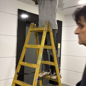 אדם על סולם מתקין תאורה בתקרה