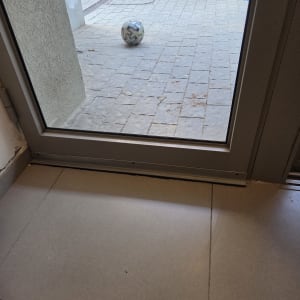 כדור על רצפת מרפסת ליד דלת זכוכית