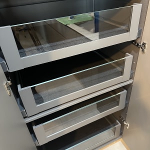 ארון עם מדפים מזכוכית ומטלית ירוקה לניקוי